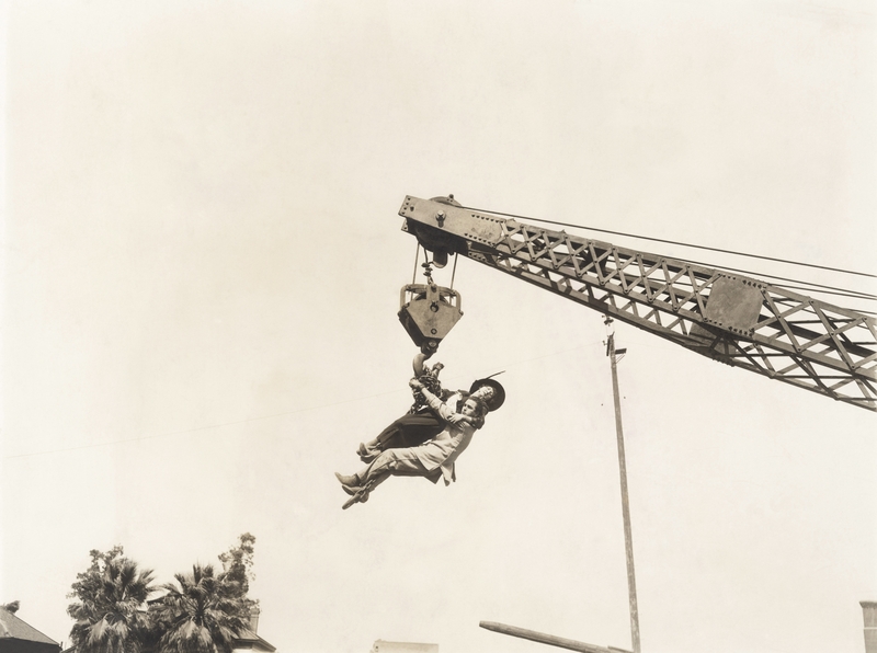 people dangling from crane